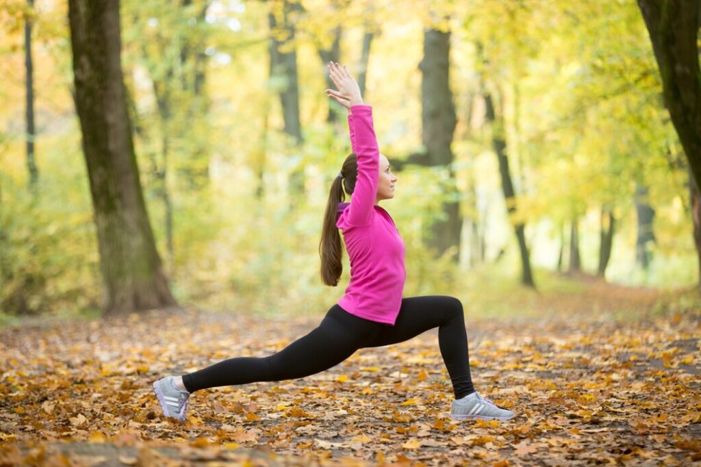 person in a pink sweatshirt and black leggings performs